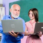 Pomóż uczyć się nowej technologii w nauce szkolnej lekcji online Wyszukiwarka mała dziewczynka z mężczyzną nauczyciel nauka na komputerze edukacja blogowanie Powrót do szkoły dojrzały nauczyciel pomóż uczniowi dziewczyna