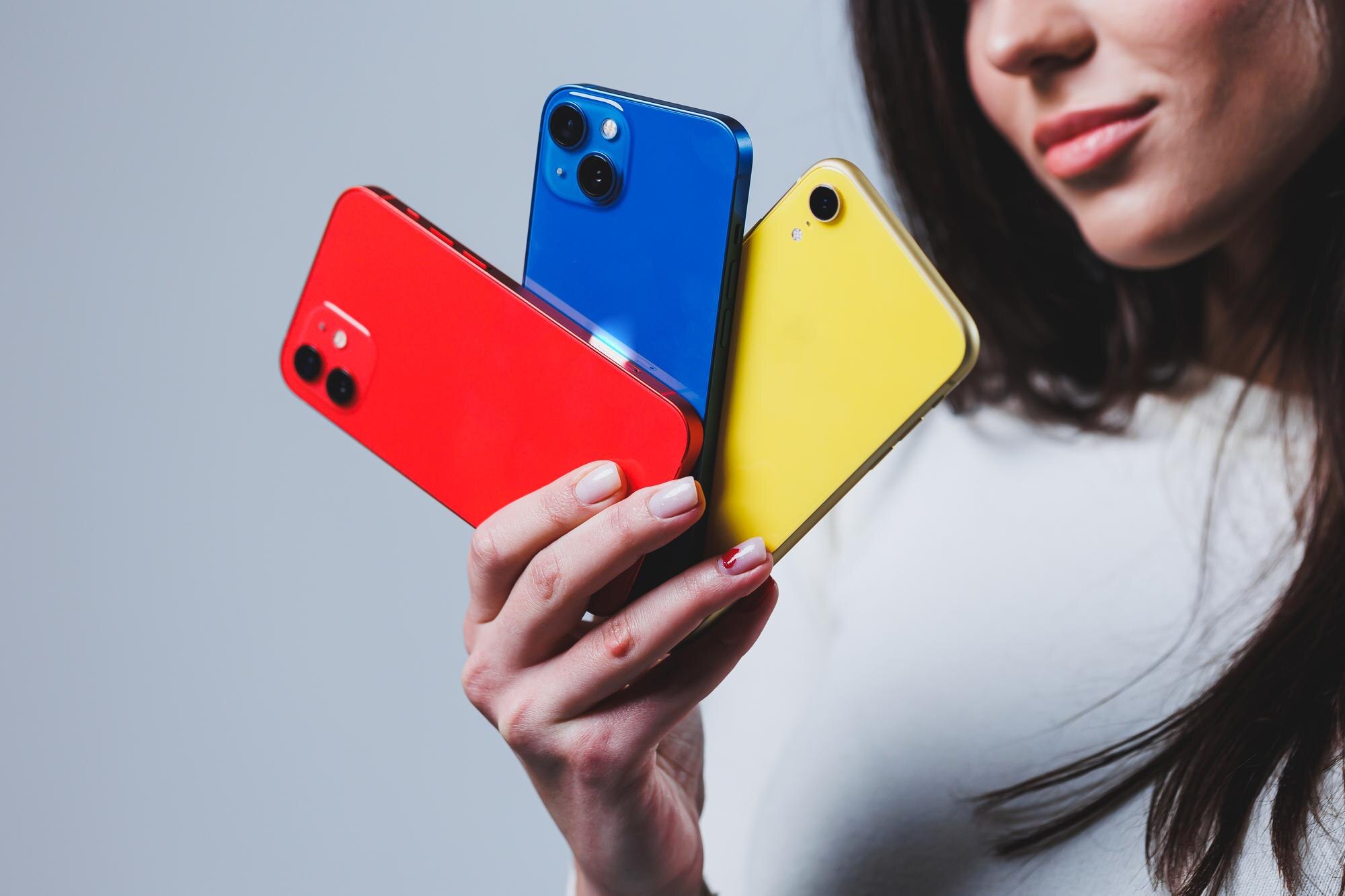 Nowe jasne telefony w rękach kobiety Ręce kobiety trzymającej kilka smartfonów