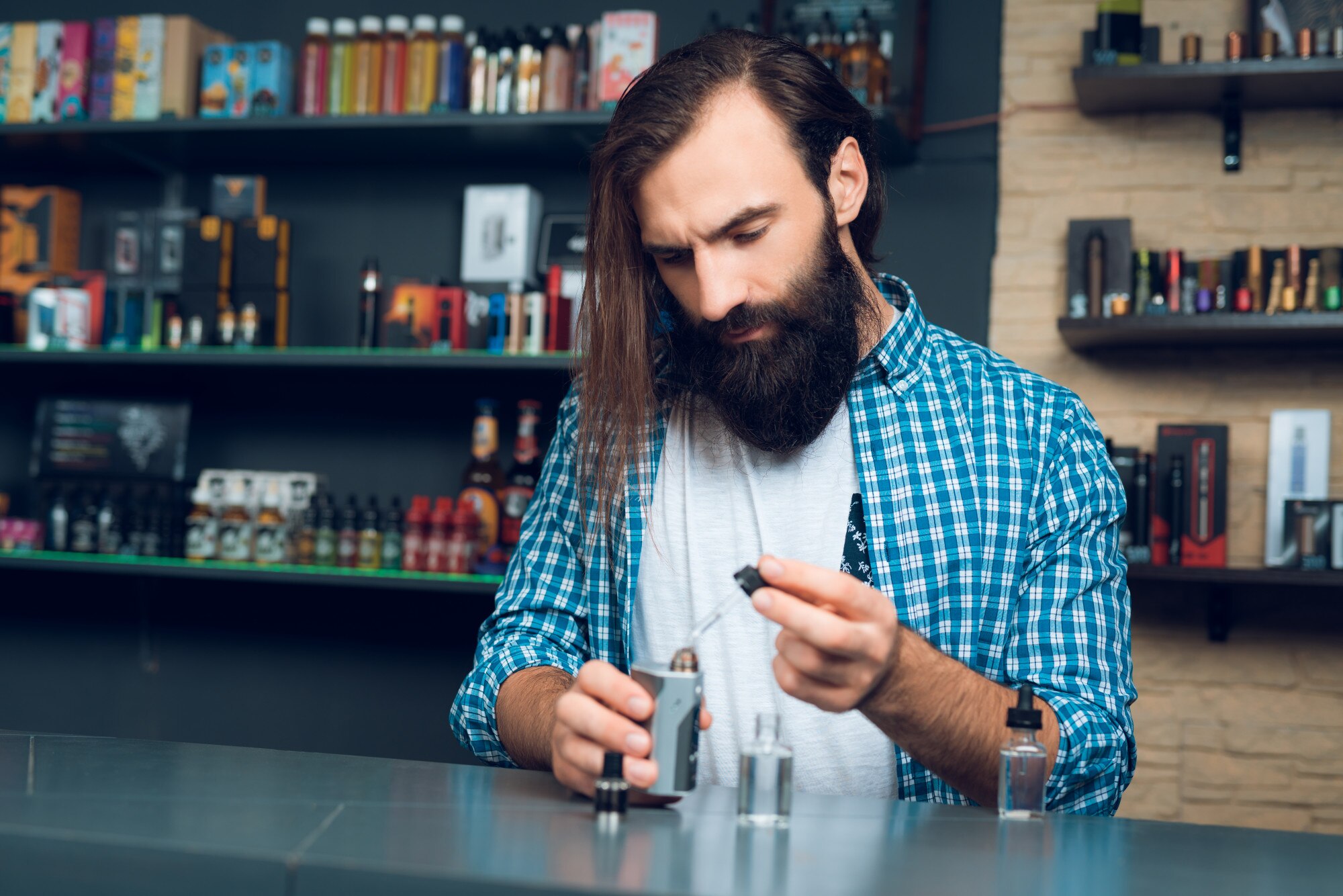 Sprzedawca w vipeshop pokazuje, jak wypełnić elektroniczny papieros.