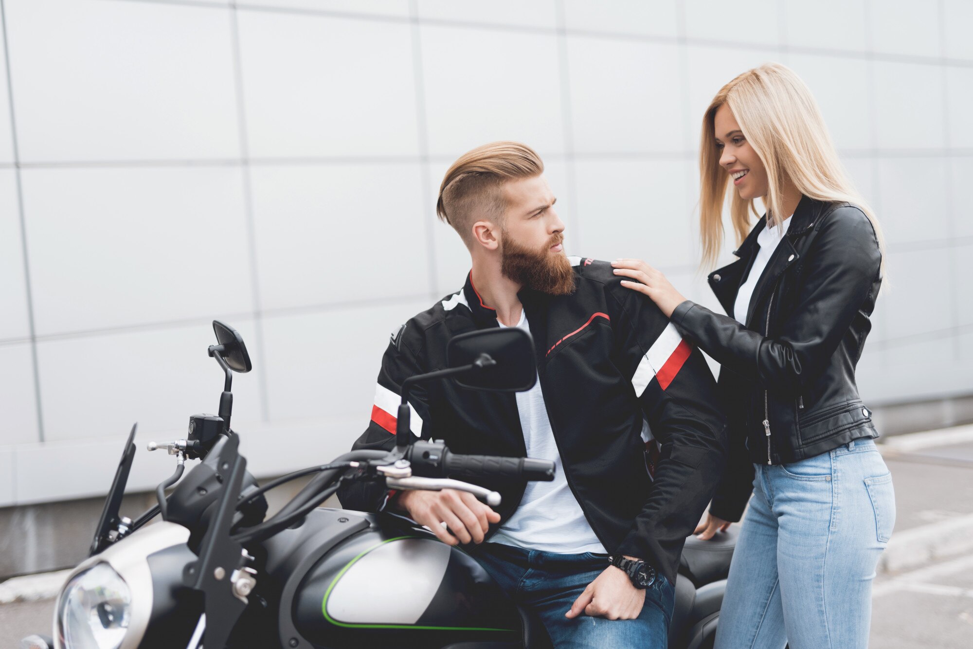 Młody facet i dziewczyna siedzi na nowoczesnym motocyklu elektrycznym