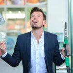 Biznesmen liczenia pieniędzy z tankowania benzyny.