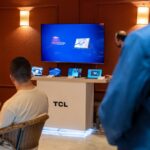 A professional business presentation showcasing new, sleek tablets and technology in a modern showroom setting.