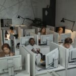 Call center with diverse employees working at computers, engaged in customer support.