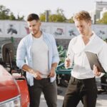 Two men engaging in a discussion about a tractor sale at an outdoor dealership.
