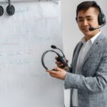 Asian man explaining a concept in a training session with a headset and flip chart.