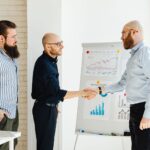 Three business colleagues engage in a productive meeting, exchanging ideas with data charts.