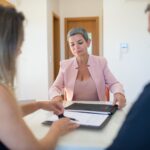 Realtor discussing contract with clients in modern office environment.