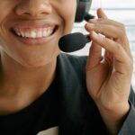 Close-up of a smiling call center representative holding a microphone.