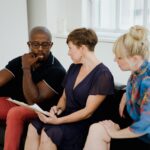 A diverse group of adults engaging in a thoughtful conversation indoors.